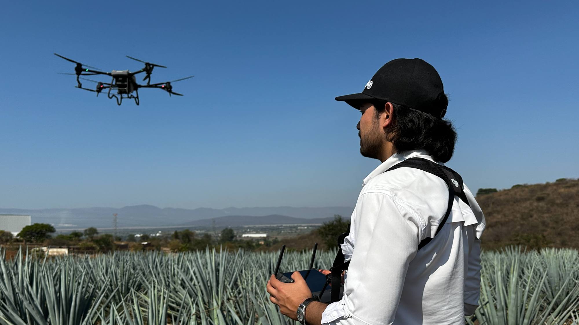 Piloto de DonDron operando un dron agrícola sobre un campo de agave